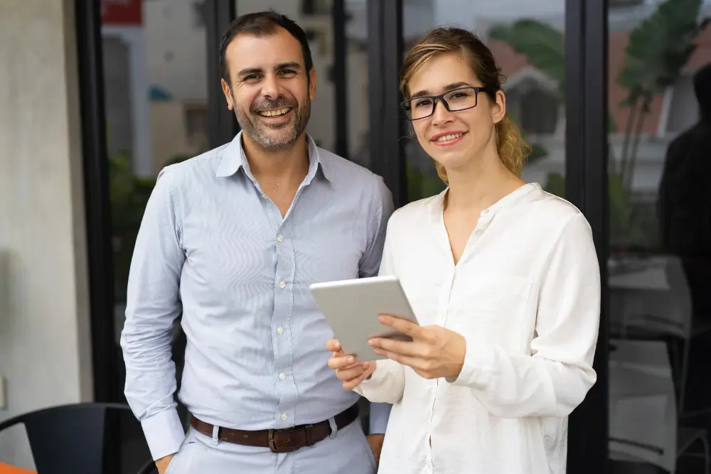 Deux distributeurs Frédéric M souriants avec une tablette, prêts à conseiller de nouveaux partenaires